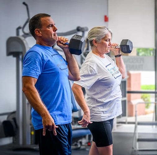people training with dumbbells at Smart Fitness